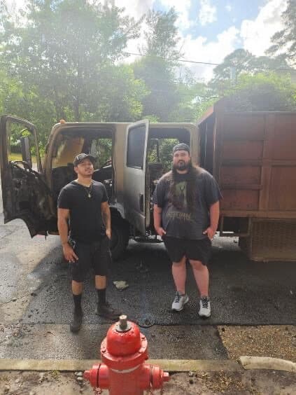 Two Got Junk NC crew members standing at the dump truck on a residential job