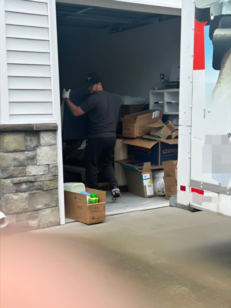 Crew member loading boxes from a garage cleanout into the truck