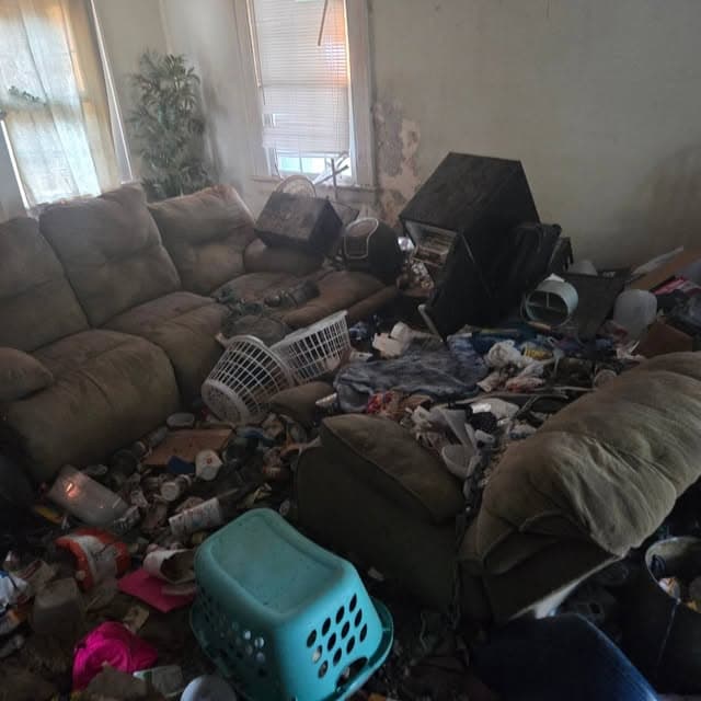 Living room packed floor to furniture before a full home cleanout