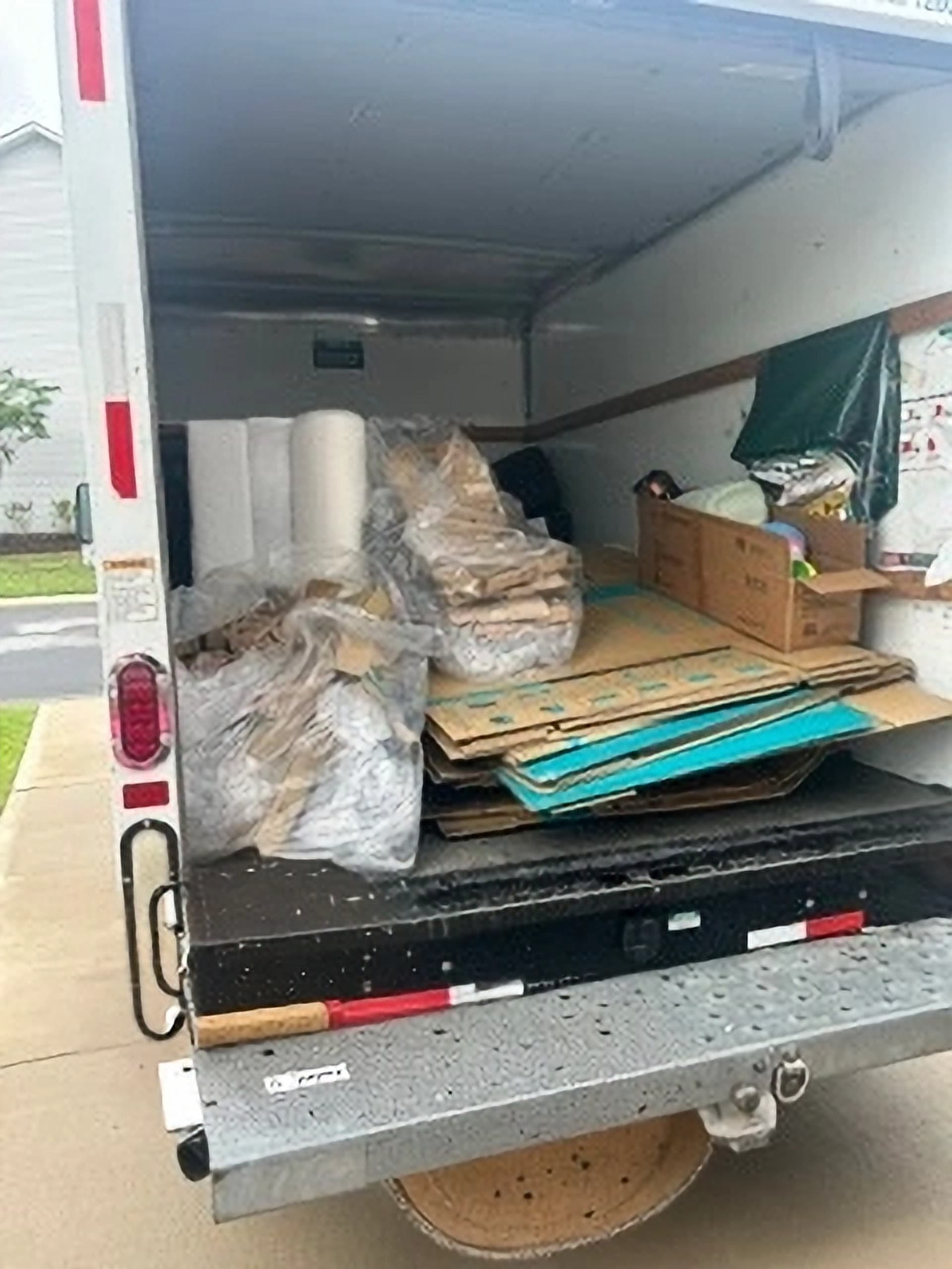 Junk removal truck loaded about half full with household debris