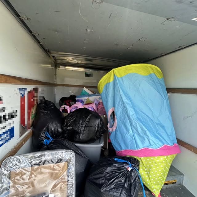 Truck loaded with bagged household items and a child's play tent