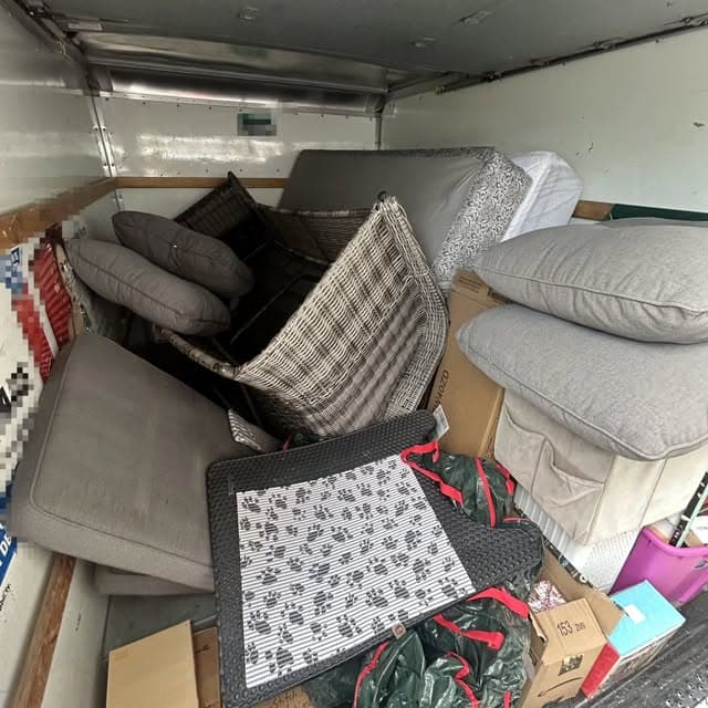 Truck loaded with patio furniture, cushions, and household goods